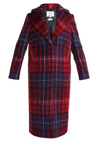 Abrigo de lana a cuadros en rojo y azul marino con un gran cuello, mangas largas y una silueta recta; presenta líneas contrastantes en amarillo y verde.