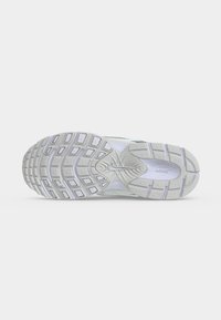 Σόλα ενός λευκού αθλητικού παπουτσιού Nike με υφασμένα σχέδια πέλματος και το λογότυπο Nike στο κέντρο.