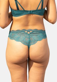 Türkisfarbene Spitzenstrings mit aufwändigen floralen Mustern, gewellten Kanten und einem Schlüssellochdetail auf der Rückseite. Weicher Stoff und verstellbare Träger.