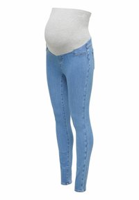 Gaiši zilas grūtnieču džinsi ar elastīgu pelēku jostasvietu, kas izstrādāta, lai ērti pielāgotos grūtnieces vēderam.