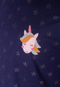 Tessuto blu marina con motivo a stelle metalliche; presenta una grafica di un unicorno con un corno rosa, criniera arancione e occhi chiusi in un design giocoso.
