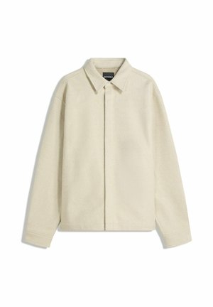 Beige langærmet jakke med spidst krave og skjulte knapper foran, vist på en hvid baggrund.