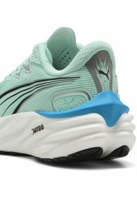 Chaussure de course légère en menthe avec une tige en maille texturée, une semelle blanche rembourrée, un accent bleu au talon et des détails réfléchissants.