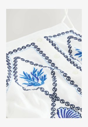 White fabric top featuring blue and navy embroidery, decorative swirl patterns, and button details. Includes marine-themed designs.