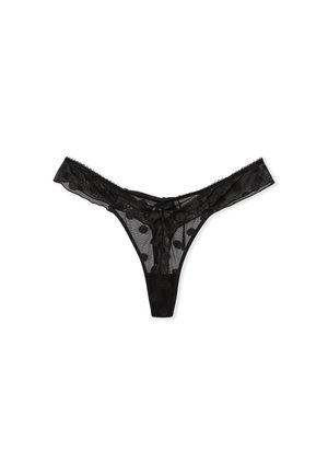 Black thong made of sheer mesh fabric with polka dot pattern. Features scalloped edges and a minimalistic design.