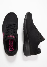 Svarta sportskor med ovandel i mesh, vadderad krage och gummisula. "Kappa"-logotyp i rosa accenter på sidan och tungan.