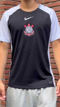 Črno-bela športna majica s kratkimi rokavi, s središčnim logotipom in ukrivljenim izrezom. Izdelana iz gladkega, zračnega blaga.