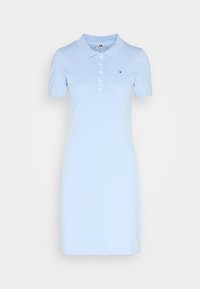 Lichtblauwe polojurk gemaakt van katoen. Heeft een kraag, korte mouwen en een knoopsluiting. Subtiel logodetail op de borst.