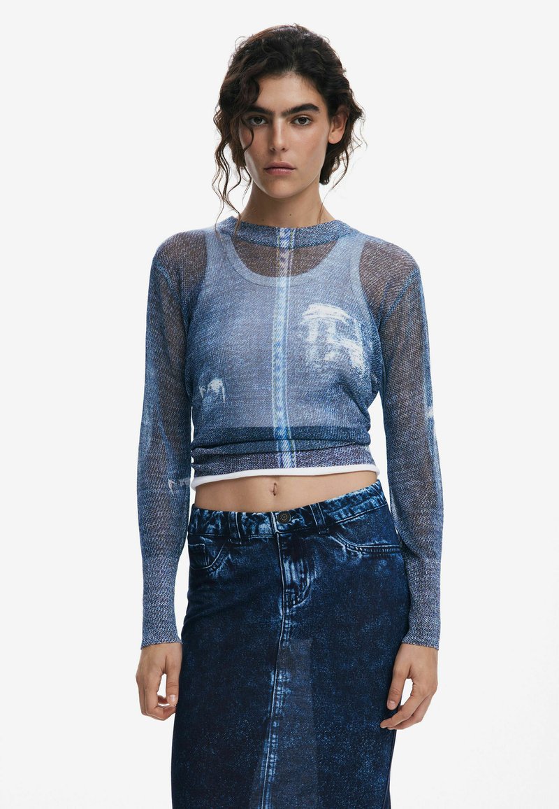Blue mesh long-sleeve top with denim pattern; cropped design. Paired with high-waisted denim skirt. Textured fabric with visible seams.