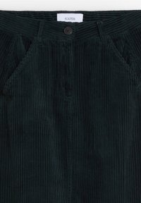 Pantalons en velours côtelé vert foncé avec des côtes verticales, dotés d'une fermeture à un seul bouton, de passants de ceinture et de poches latérales. Étiquette visible au niveau de la ceinture.