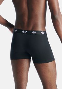 Svarta mäns boxershorts med en åtsittande design, elastiskt midjeband med vit Adidas-logotyp och en slät textur.