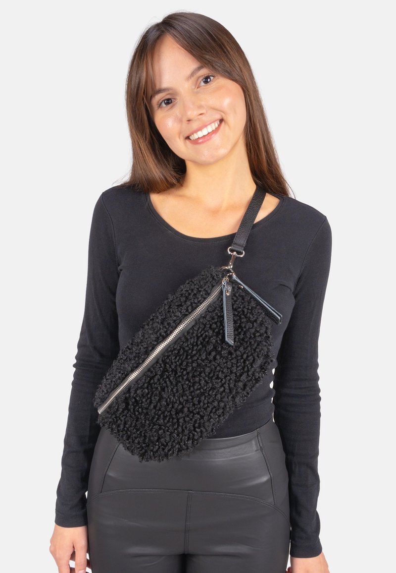 Schwarze, strukturierte Tasche mit einem flauschigen Äußeren, silbernem Reißverschluss und verstellbarem Riemen. Verfügt über Lederakzente und eine rechteckige Form.