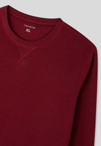 Sweatshirt borgogna realizzato in morbido misto cotone, con scollo rotondo, maniche lunghe e dettagli cuciti sulle cuciture delle spalle.