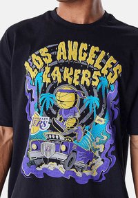T-shirt en coton noir avec un graphic coloré d'un joueur de basketball cartoon, des palmiers et une voiture vintage, avec le texte "Los Angeles Lakers".