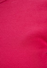 Ribbad tyg i en ljusrosa färg, som visar en slät yta med vertikala linjer, vilket betonar mjukhet och flexibilitet.