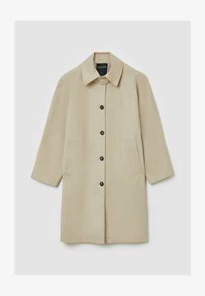 Beige Mantel mit geradem Schnitt, Kragen und Dreiviertelärmeln. Mit schwarzen Knöpfen und zwei vorderen Taschen. Glatte Stofftextur.