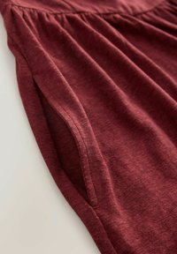Burgundia kleit tekstuuriga viimistlusega, millel on kogutud materjal vööl ja küljetaskud, et lisada detaili.
