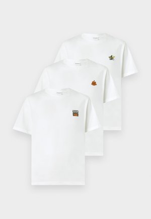 Trois t-shirts en coton blanc à col rond. Chacun présente des broderies différentes : une fleur, un soleil rayonnant et une bicyclette.