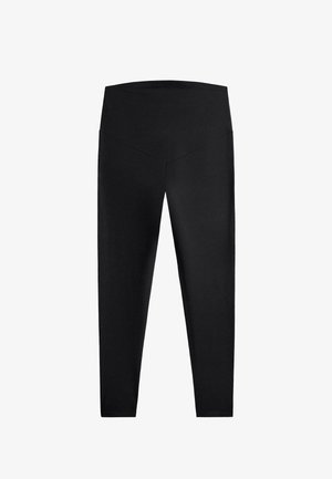 Črne legice z visokim pasom in V-oblisišnim šivom spredaj, izdelane iz gladkega, raztegljivega materiala, prikazane položene na ravni površini na belem ozadju.