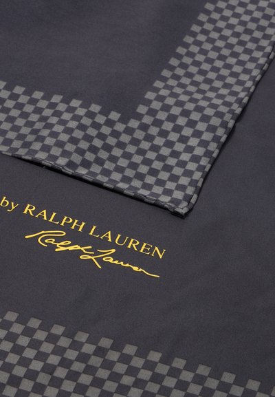 Černý materiál se šedým kostkovaným vzorem po okraji a zlatým textem, obsahující podpisy "by RALPH LAUREN" a "Ralph Lauren".