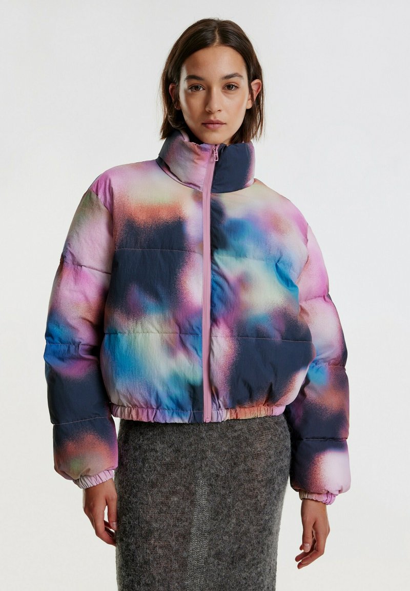 Pufferjack die voorzien is van een multicolor gradiëntpatroon met blauwe, roze en paarse tinten. Het heeft een hoge kraag en een voorkant met rits.
