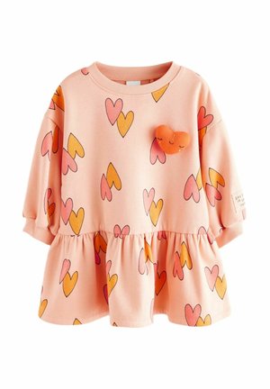 Sweat-shirt rose avec un design péplum, présentant des motifs de cœurs multicolores en orange, rose et rouge. Comprend un écusson en forme de cœur orange.