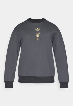 Tumesinine puuvillane dressipluus, millel on soonikkoes krae ja varrukaotsad. Kuldsed graafikud sisaldavad Adidas logo ja Liverpooli jalgpalliklubi embleemi.