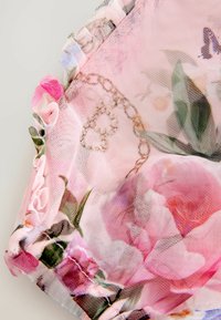 Rozā sietveida audums, ko rotā ziedu raksti ar rozēm un akcentiem. Saspraužamās malas piešķir tekstūru un detaļas dizainam.