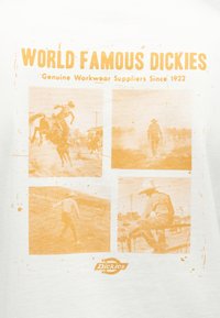Τέσσερις φωτογραφίες σε στυλ παλαιού τύπου σε αποχρώσεις σέπια με καουμπόηδες που ιππεύουν, περπατούν και ξεκουράζονται, με το λογότυπο «World Famous Dickies» και τη σήμανση ρούχων εργασίας πάνω και κάτω.