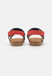 Røde og marineblå sandaler med justerbare stropper, korksåle og myk innersåle. Åpen bakdesign med teksturert fotseng for komfort.