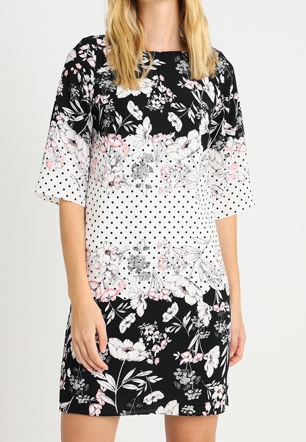 Květinové šaty s puntíky v černé, bílé a růžové barvě. Krátké rukávy, kulatý výstřih a přiléhavý silueta.