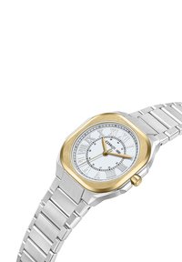 Reloj octogonal de plata y oro con una esfera blanca, números romanos, manecillas doradas y una correa de eslabones de acero inoxidable. Presenta una corona en el costado.