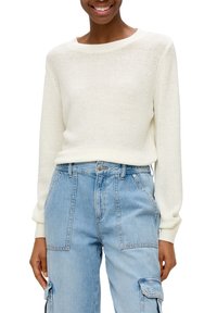 Maglione in maglia morbida di colore crema chiaro con ampia scollatura a girocollo. Abbinato a pantaloni cargo in denim azzurro chiaro a vita alta con tasche laterali.