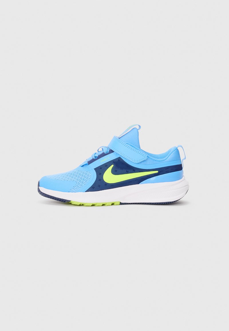 Chaussure de sport bleue avec une tige en mesh, dotée d'un accent marine, d'un logo vert fluo, d'une sangle réglable et d'une semelle blanche avec un profil texturé.