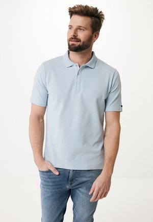 Helles blaues Polohemd aus strukturiertem Stoff, mit einer Drei-Knopf-Leiste und kurzen Ärmeln, kombiniert mit blauen Jeans.