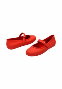 Zapatillas de ballet de goma rojas con punta redondeada, que cuentan con una correa central y hebilla. Textura suave con un acabado mate.