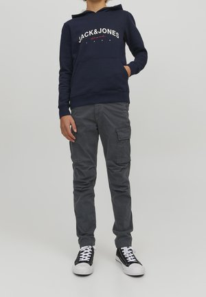 Marine hoodie met het "JACK&JONES" logo, gecombineerd met grijze cargo pants met meerdere zakken. Zwart-witte sneakers maken de outfit compleet.