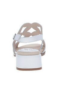 Sandali bianchi con una suola texturizzata, una cinghia alla caviglia regolabile e un design decorativo a ritagli sulla parte superiore. Presentano un tacco basso.