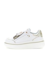 Pantofi sport din piele albă cu talpă groasă, accente aurii și ciucuri decorative în vârf, expuși pe un fundal alb.
