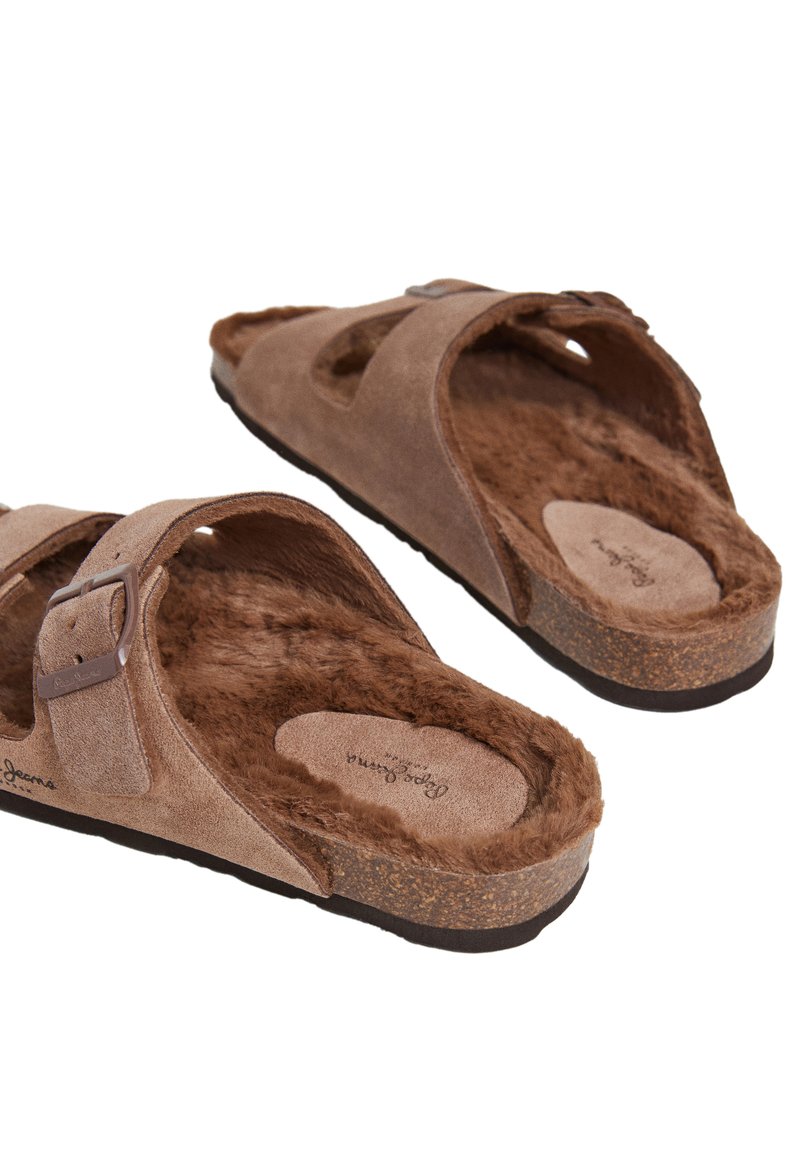 Braune Wildleder-Sandalen mit zwei breiten Riemen, verstellbarer Metall Schnalle, mit Fell gefüttertem Innenbereich und Korksohle. Texturierte Oberfläche für Komfort.