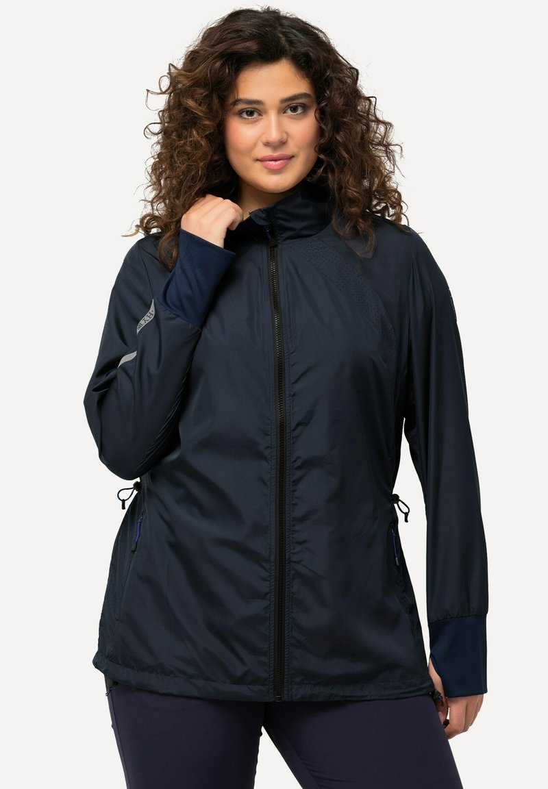 Granatowa kurtka przeciwwiatrowa z wysokim kołnierzem, pełnym zamkiem, regulowanym ściągaczem na dole oraz kontrastowymi wewnętrznymi mankietami o gładkiej fakturze.