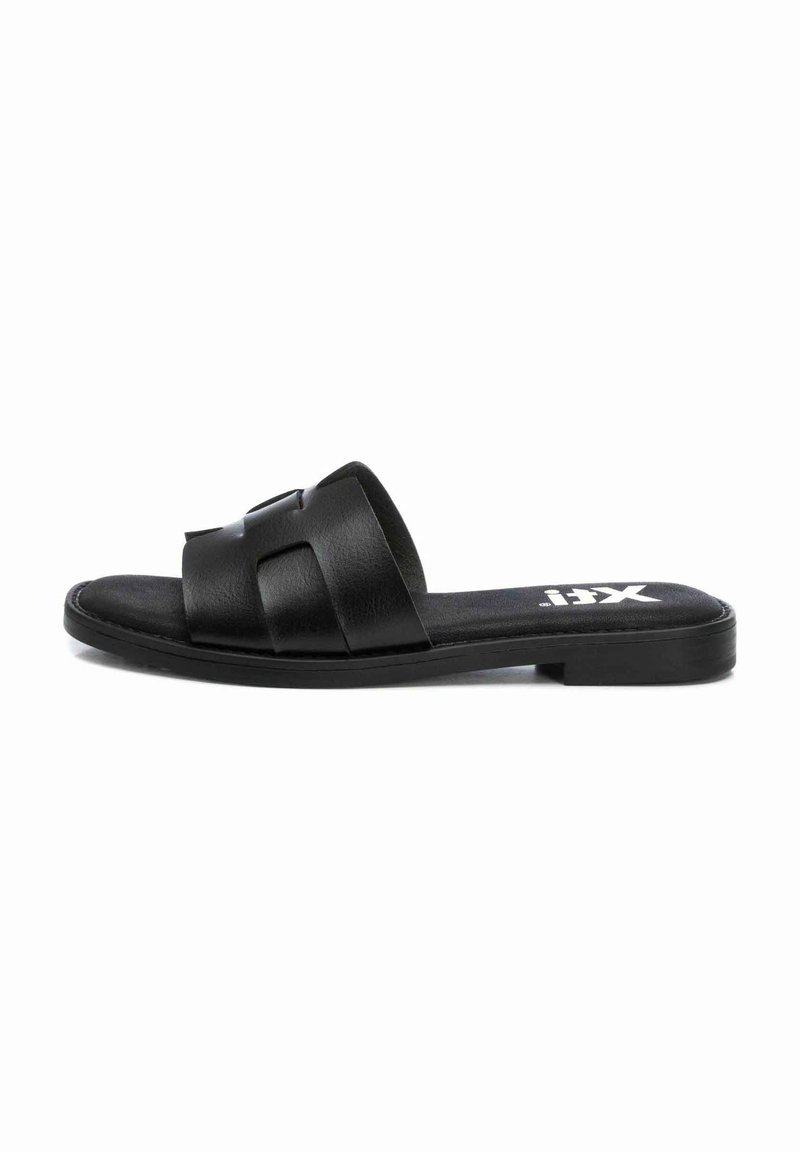 Sándalo deslizante de cuero negro con dos correas anchas, suela plana y textura suave. Presenta un diseño minimalista y una marca sutil.