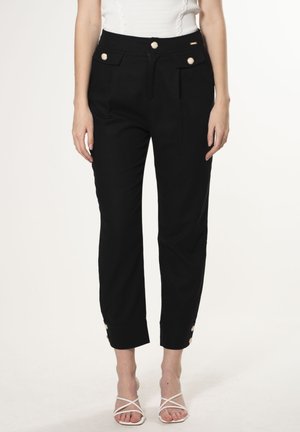 Zwarte high-waisted broek met zijzakken en gouden knoopaccenten, met een taps toelopend ontwerp en omgeslagen pijpen. De stof lijkt glad.