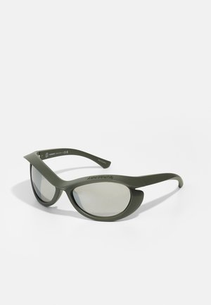 Olive green sunglasses with curved frames, grey lenses, and slim temples. Features a distinctive sporty design and smooth texture.