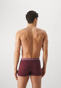 Burgunderfarbene Boxershorts mit flexiblem Bund, der ein "PIER ONE"-Logo trägt, glatter Textur und enger Passform, von hinten betrachtet.