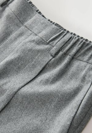 Grauer Sweatshirtstoff mit weicher Textur, ausgestattet mit einem elastischen Bund und dezenten Nähten. Nahaufnahme des Materials.