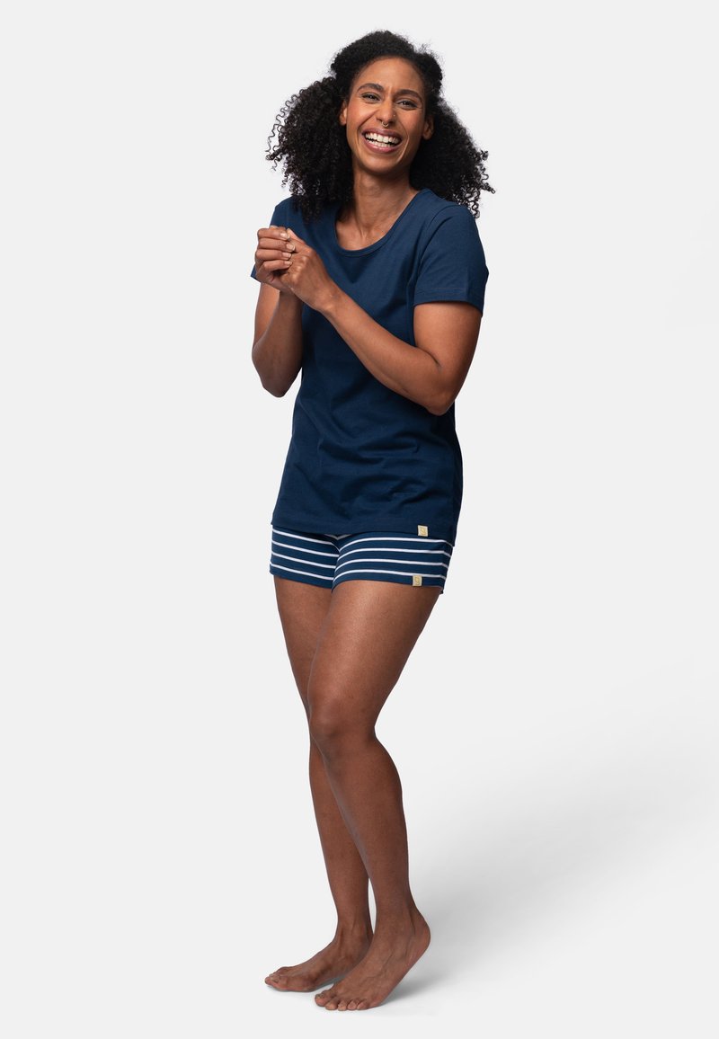 T-shirt in cotone blu abbinato a pantaloni corti a righe blu e bianche. L'outfit presenta una vestibilità rilassata e include un accento di logo discreto.