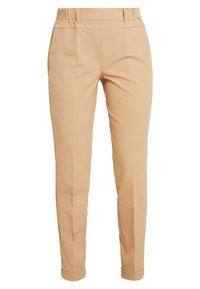 Pantalons beiges avec une texture lisse, dotés d'une large ceinture élastique, de jambes fuselées et d'ourlets retroussés. Pas de poches visibles ni de motifs.