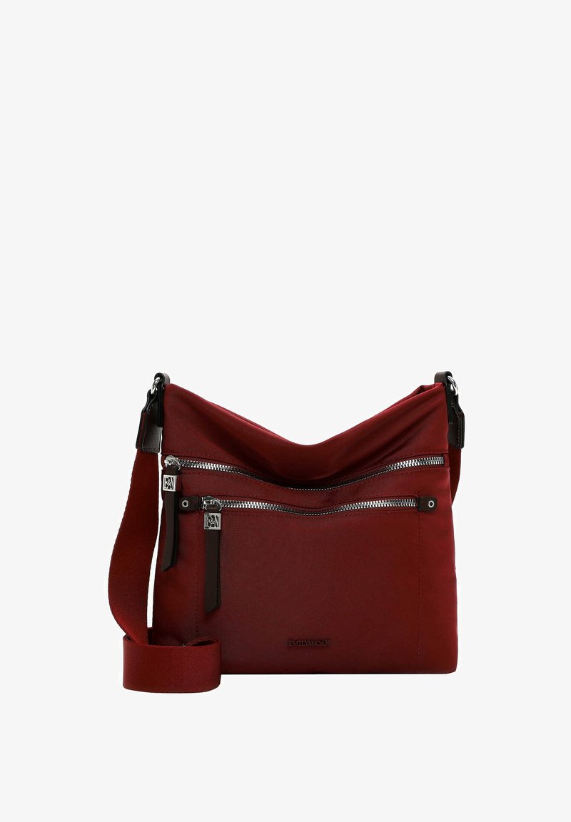 Bolso cruzado de tela roja con dos bolsillos frontales con cremallera, correa ajustable y detalles de cuero. Textura suave y diseño casual.