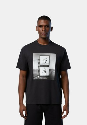 T-shirt in cotone nero con stampa grafica frontale che mostra foto e la parola "NORTH" in basso; design morbido, colletto rotondo, maniche corte.